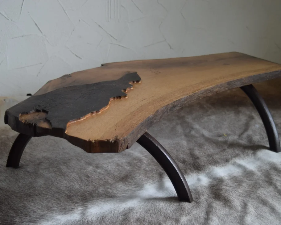 Der Upcycling-Couchtisch 'Scoark' aus massiver Eiche und Metall-Fassringen, fotografiert in einer schrägen Gesamtansicht