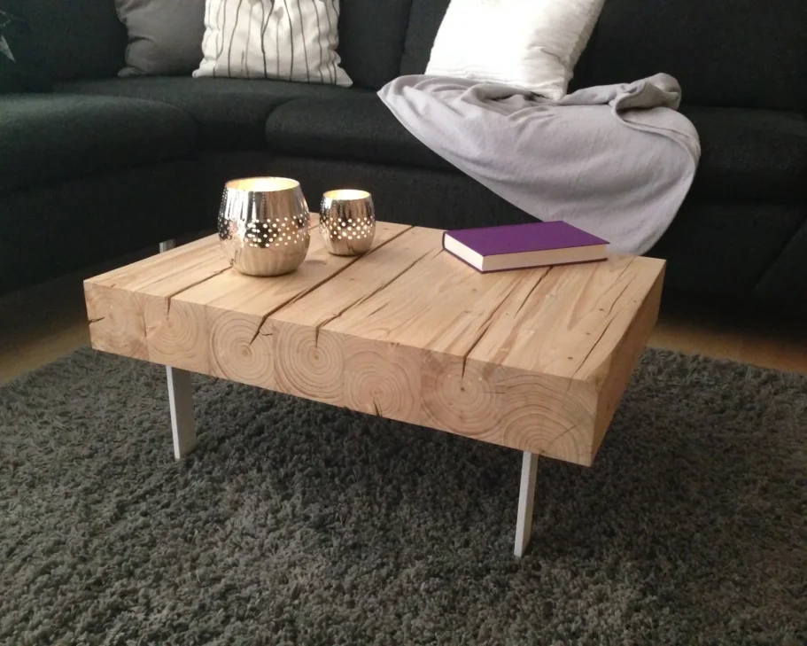 Der kompakte Couchtisch aus massiven Holzbalken auf schlanken Metallfüßen verbindet pure Natur mit modernem Design. Ein Unikat von made2be