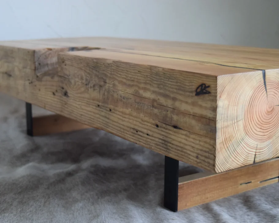Couchtisch 'HeavyBeam': Ein massiver, alter Holzbalken aus einem Kornspeicher, aufgearbeitet als exklusives Unikat-Möbelstück.